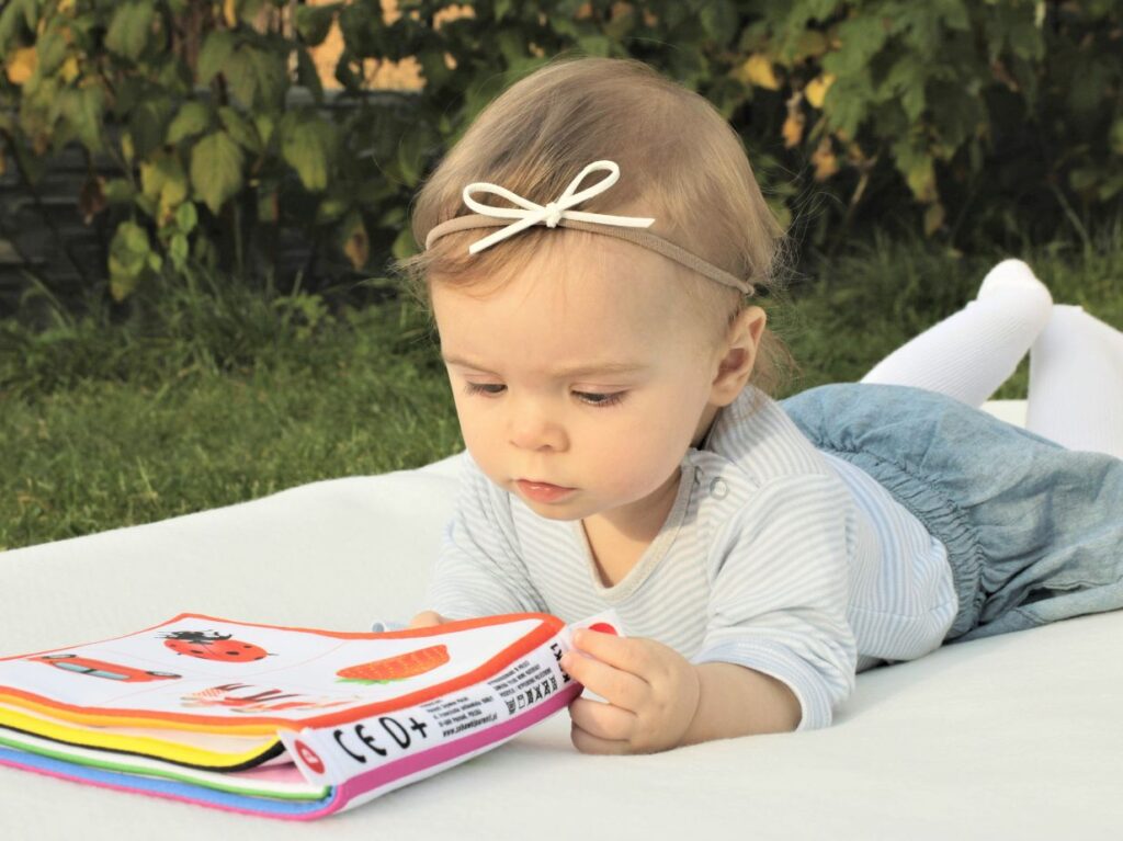 Bebé de 4 meses, agarrando un libro