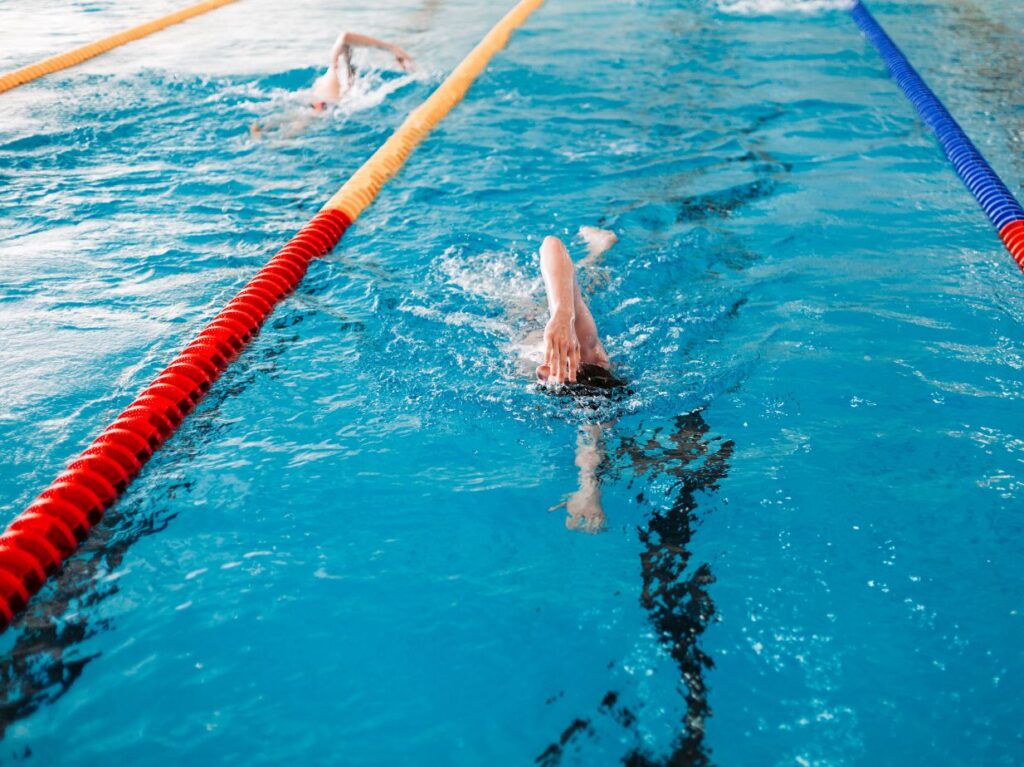 Dos nadadores compitiendo en una competencia de natación, en una piscina olímpica 