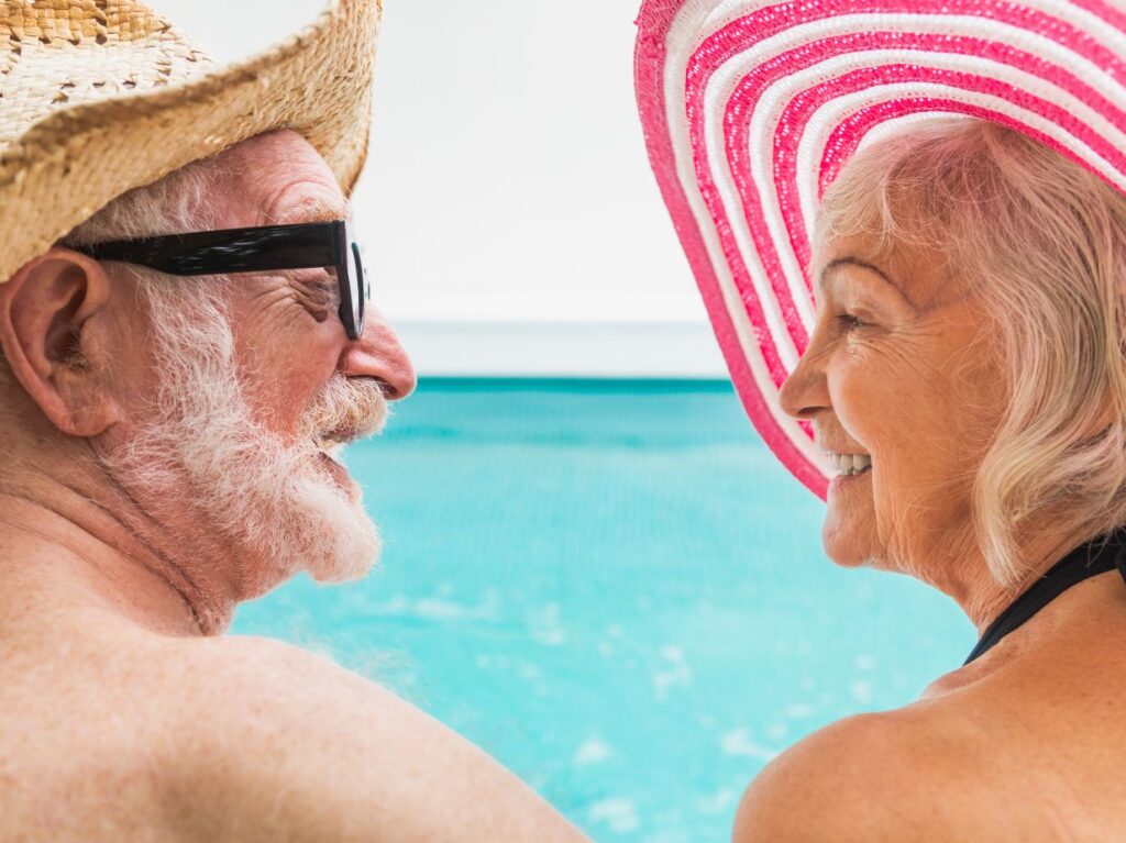 Un hombre y una mujer de la tercera edad, en una piscina, socializando