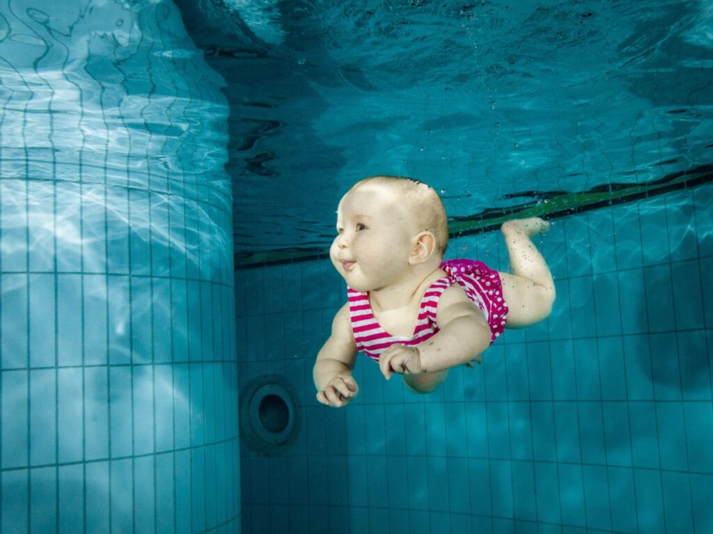 Un bebé practica una de las actividades acuáticas para estimular el desarrollo infantil