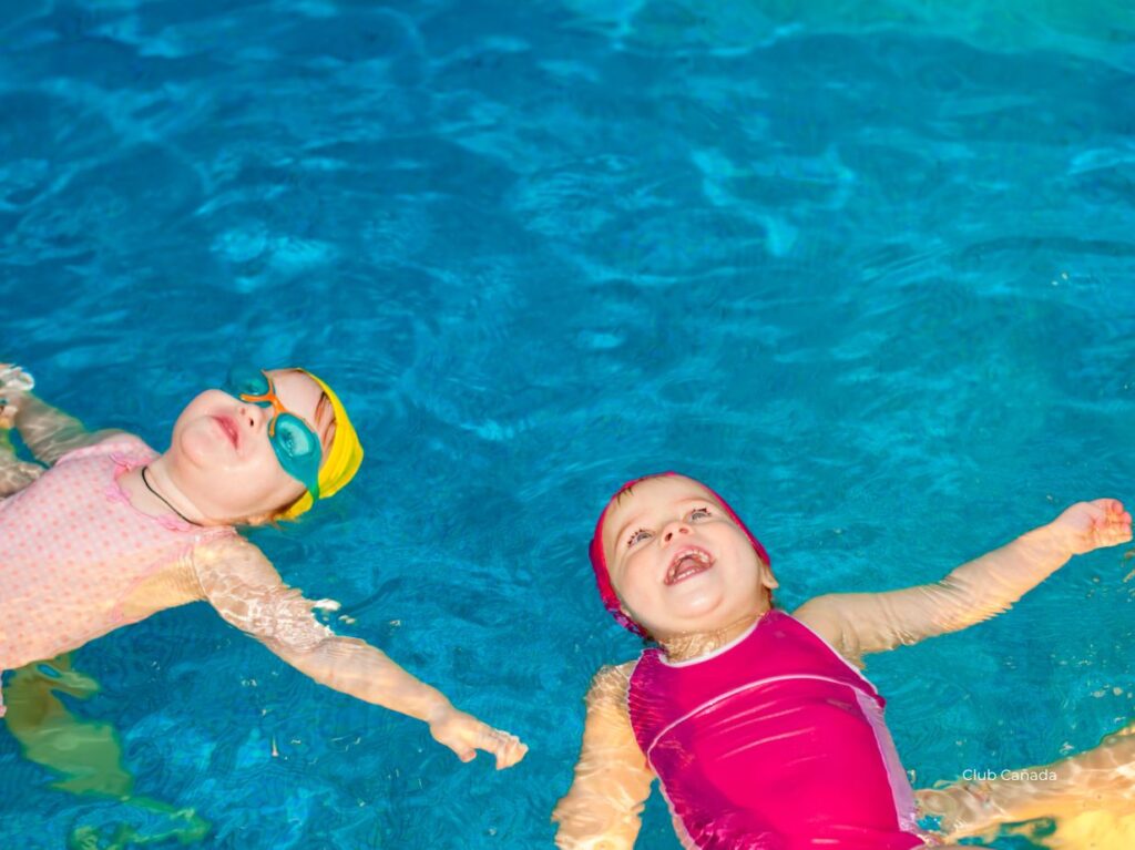 Bebés flotando en una alberca, durante una clase de natación 