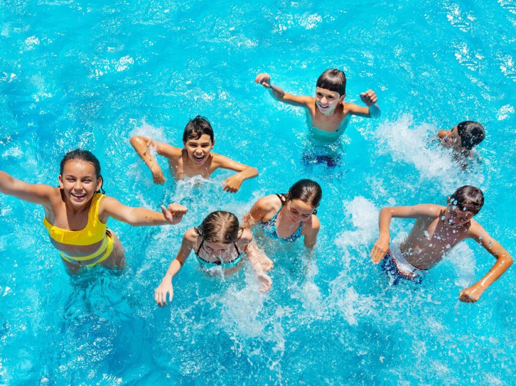 Niños contentos saltando en una alberca