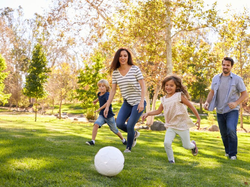 Una familia feliz practicando futbol