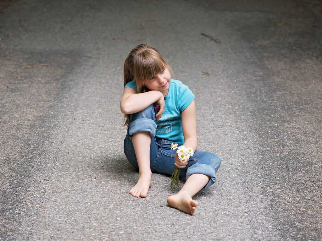 Niña con ansiedad, sosteniendo unas fotos. 