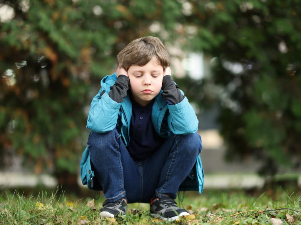 Un niño sobreestimulado y agobiado, sentado
