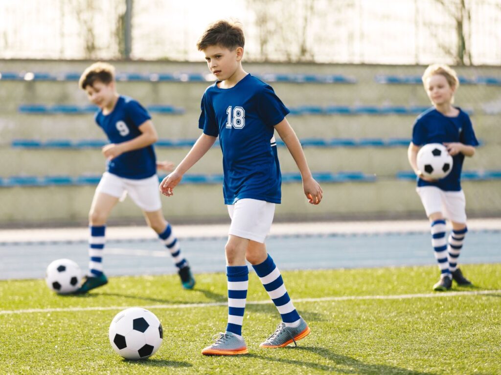 Niños introvertidos jugando fútbol