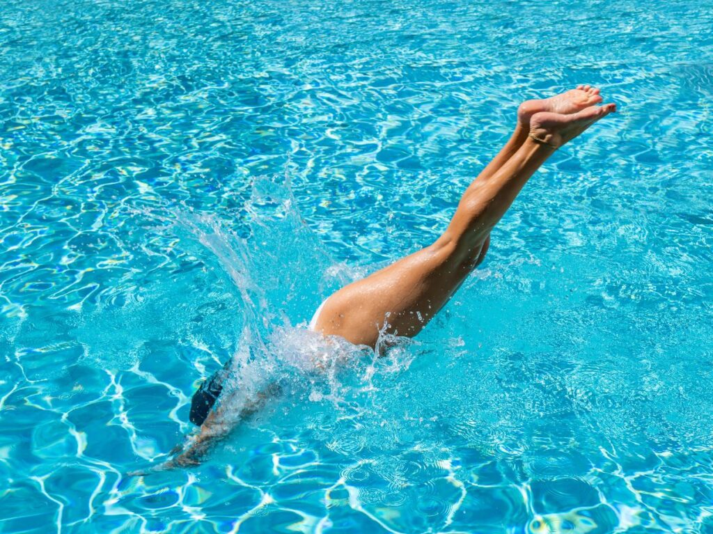 Persona combatiendo el calor en CDMX tirándose a la piscina